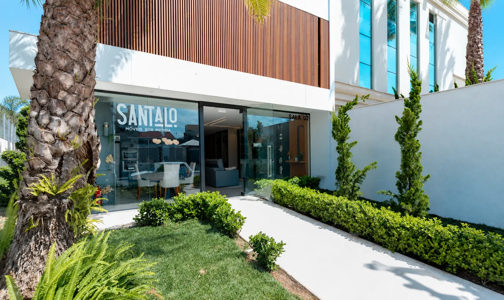 Fachada da loja Santalo em Itajaí, com letreiro no vidro e jardim frontal